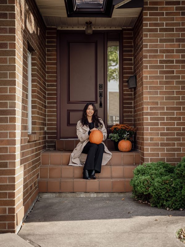 Agent sitting on stoop with pumpkins — Coming Soon brand photo