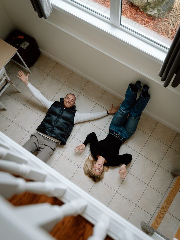 Two agents lying on entryway floor overhead shot — Coming Soon brand photo